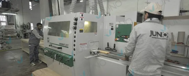 Artisan Juno enfournant du bois dans une machine de menuiserie